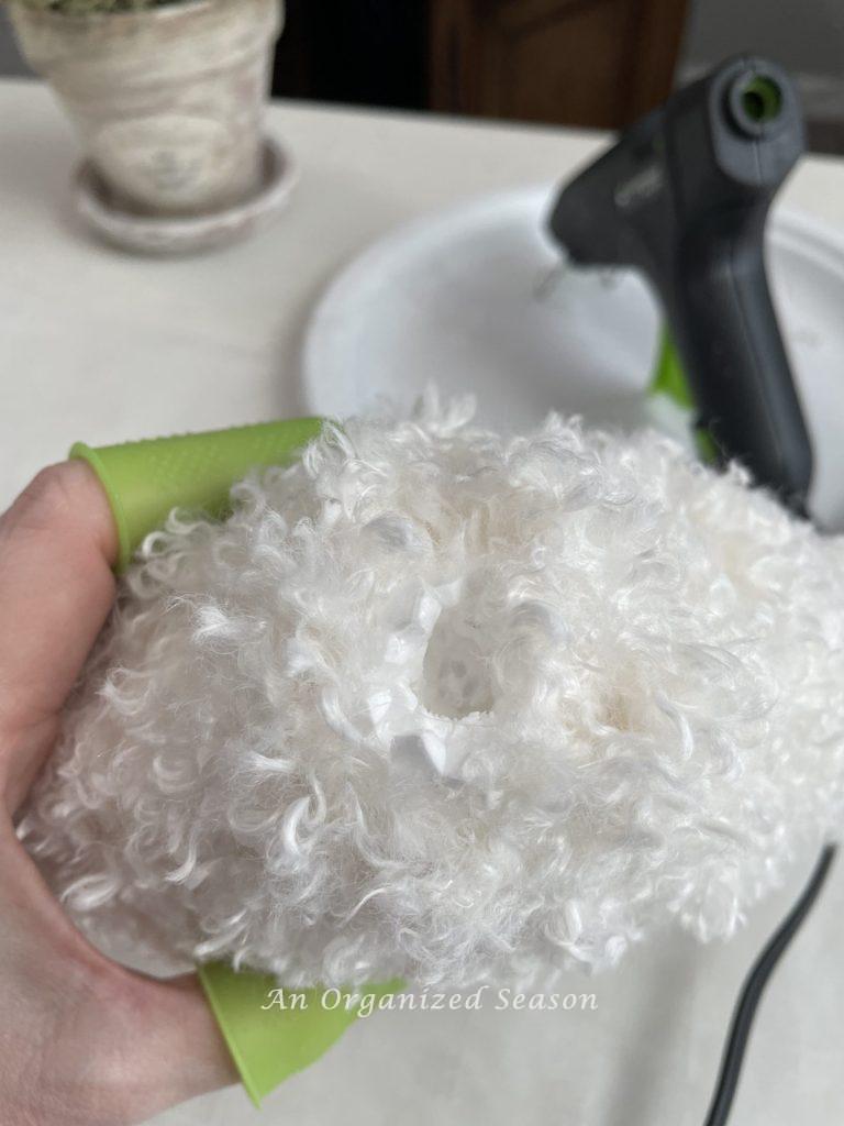 A hole in the bottom of a yarn-covered Dollar Tree heart.