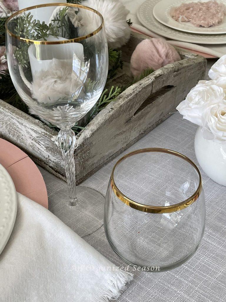 Crystal wine and water glass set on a table decorated for Galentine's day.