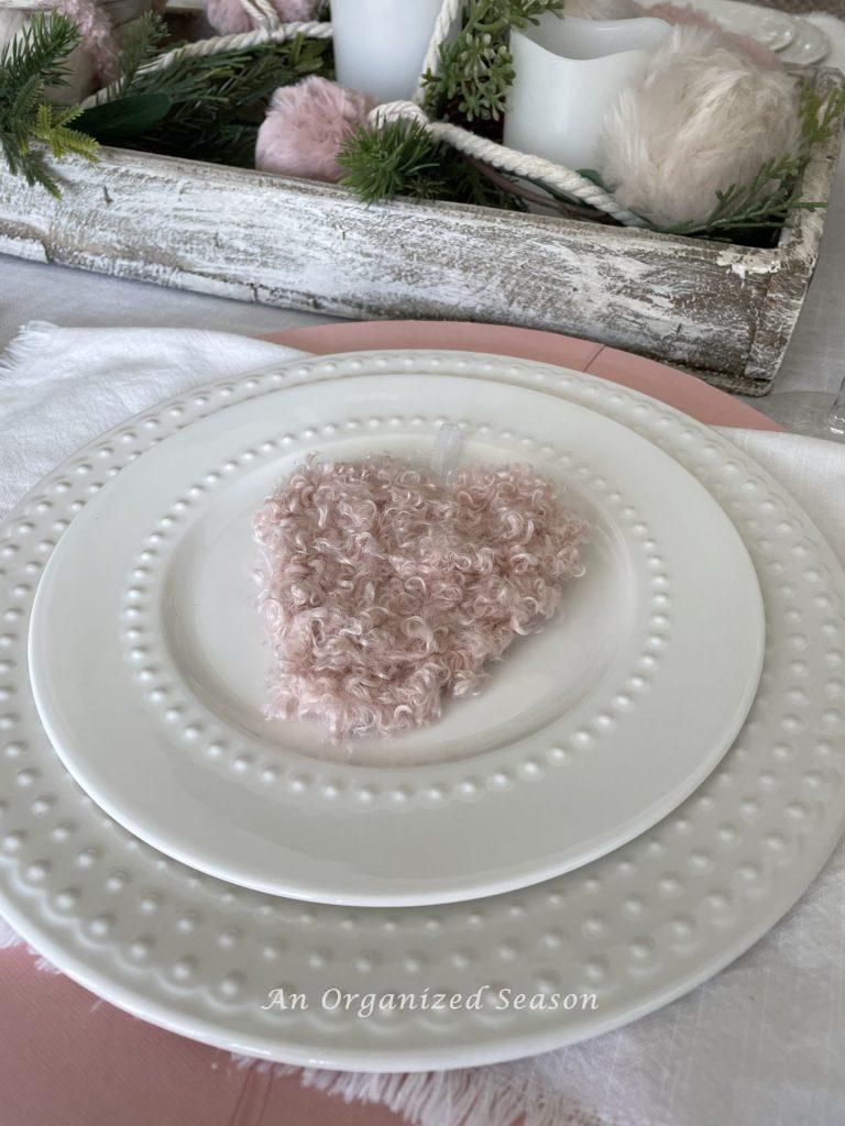 Two white plates with a pink heart, ideas to set a Galentine's table. 