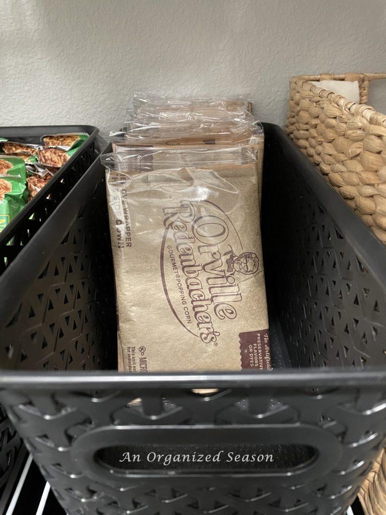 Popcorn stored in a black bin in a pantry. 