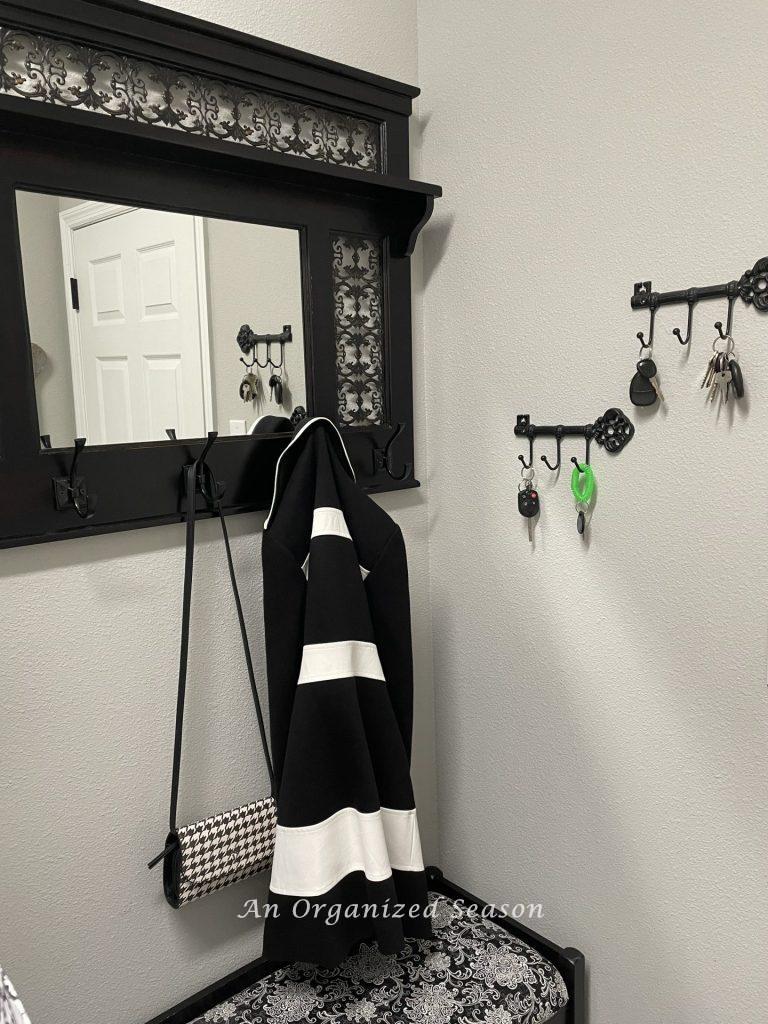 Coat, purse, and keys hanging by the door in the laundry room. 