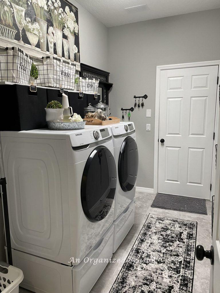 An organized laundry room decorated in black, white, and gray. 