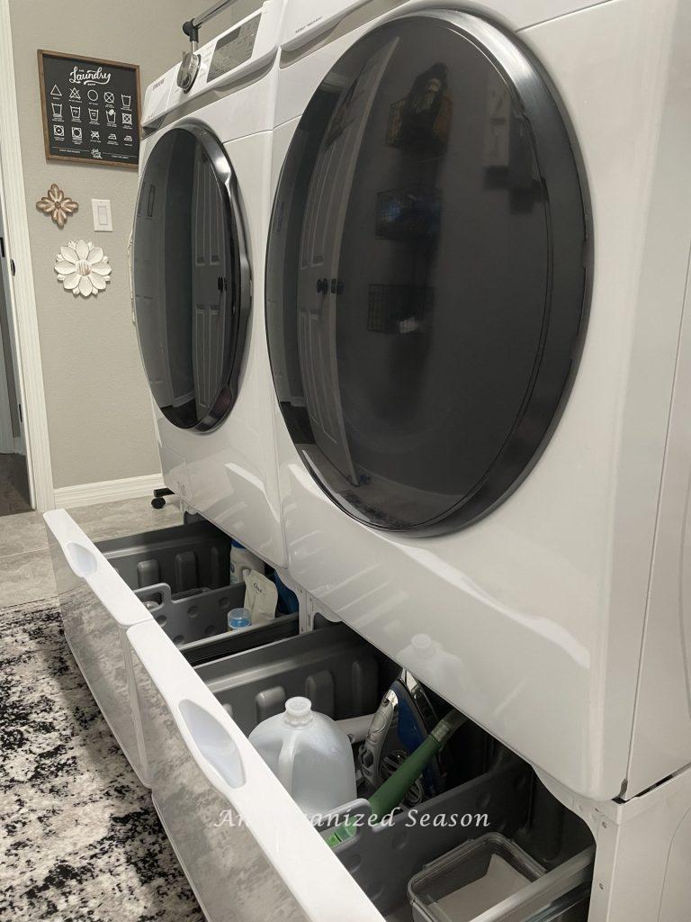 Pedestal drawers under a washer and dryer that are pulled open. 