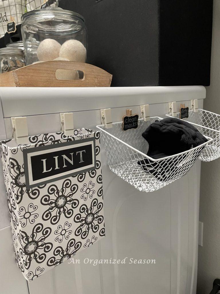 Attach a lint bin and small wire baskets for clean and dirty masks on the side of the dryer,  tip seven to create an organized laundry room. 