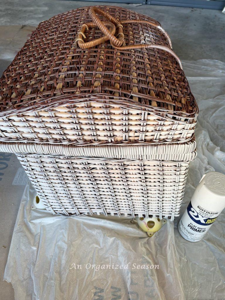 Step three to upcycle a picnic basket is to spray the top with primer.