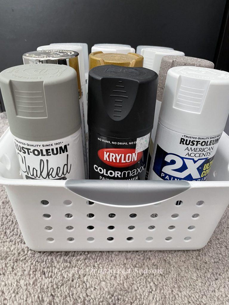 Organize must-have craft supplies by storing spray paint in a plastic tub.