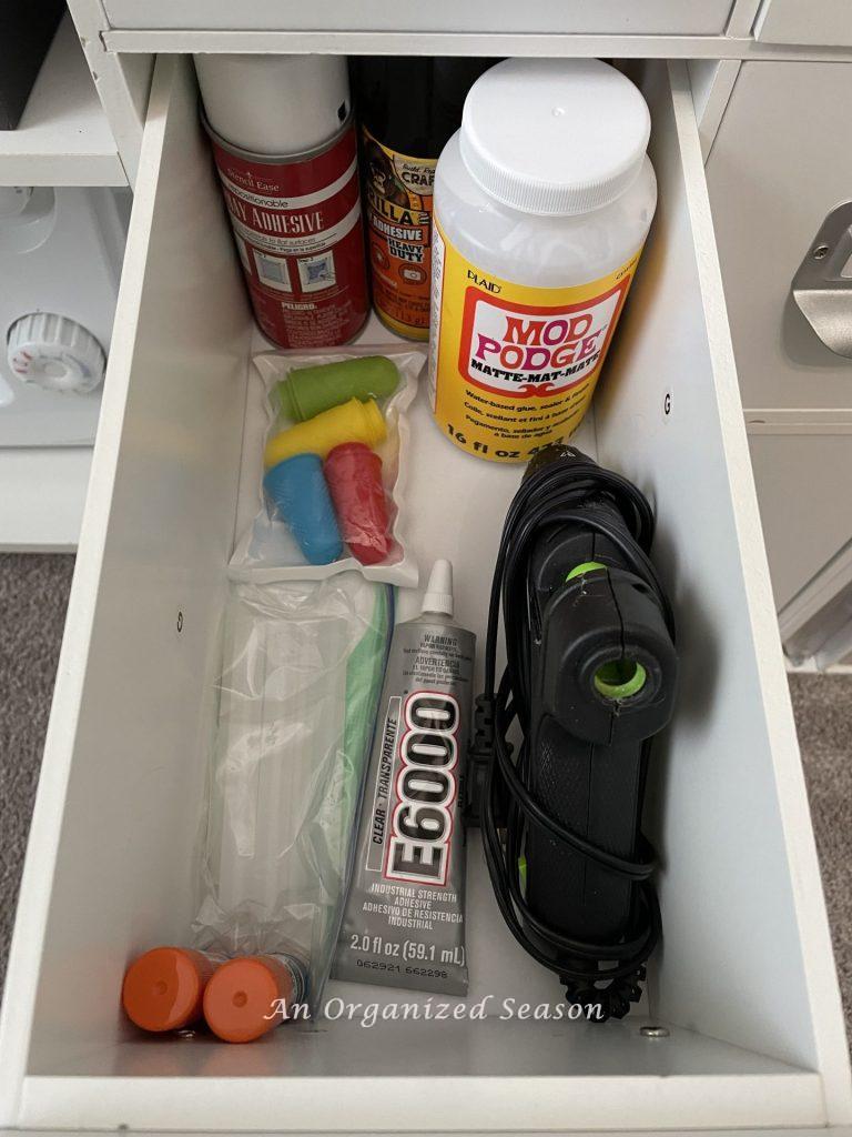 Organize must-have craft supplies by putting all types of glue, adhesives, and glue gun in a drawer together.