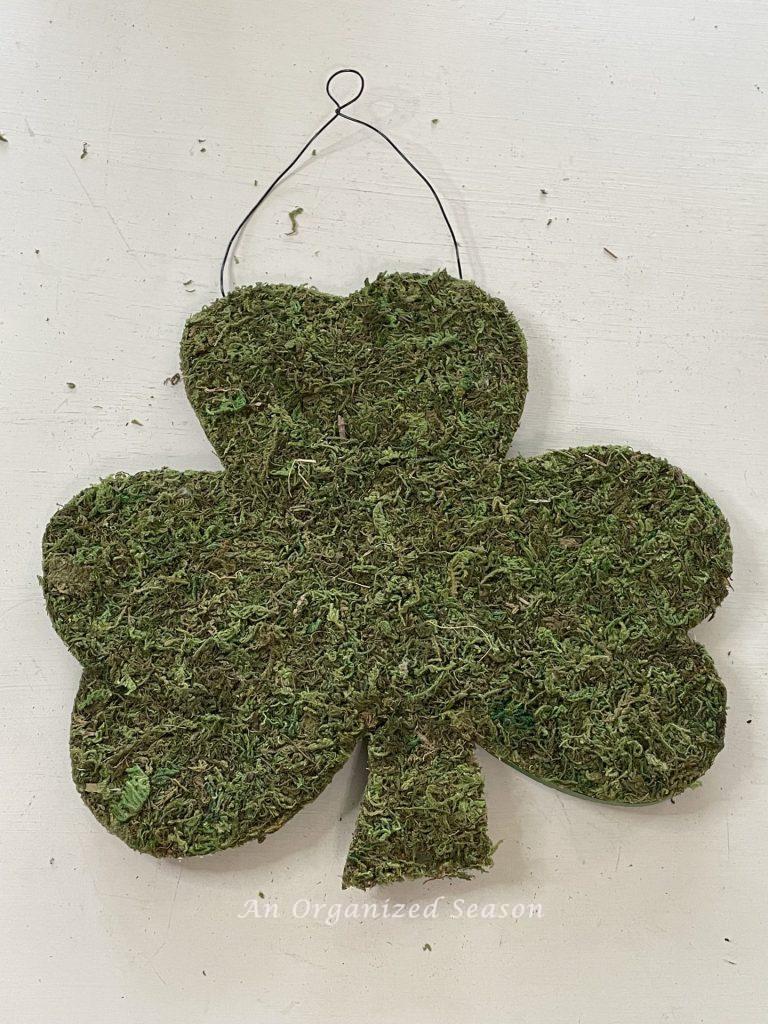 A moss sign in the shape of a shamrock.