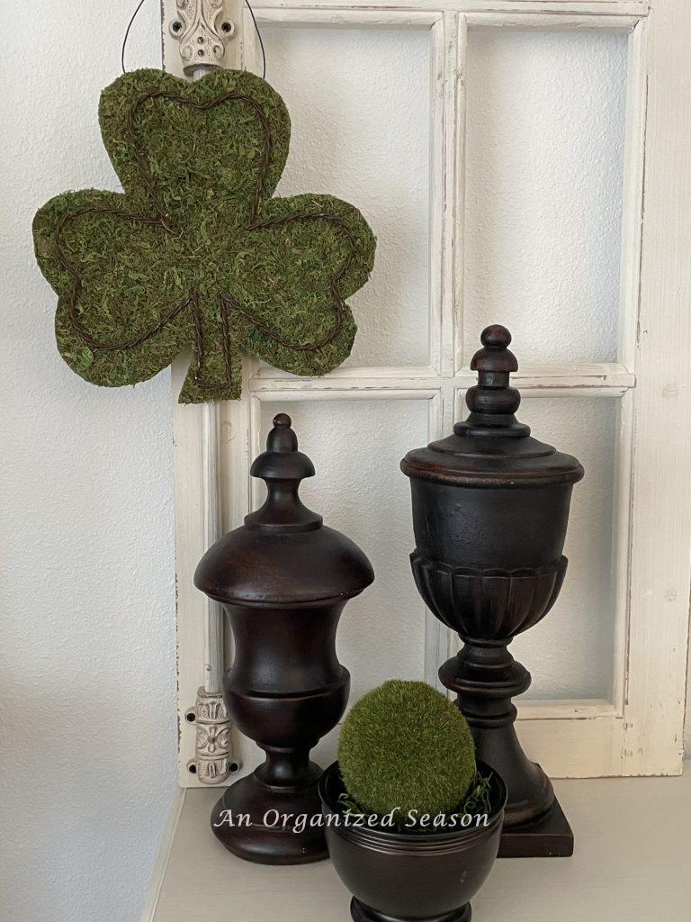 A moss shamrock hanging on a vintage window. 