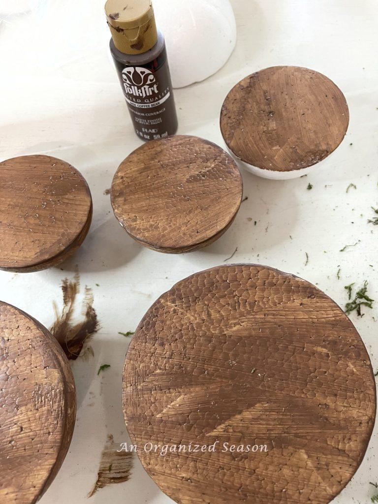 Styrofoam half balls painted brown to make moss mushroom home decor.