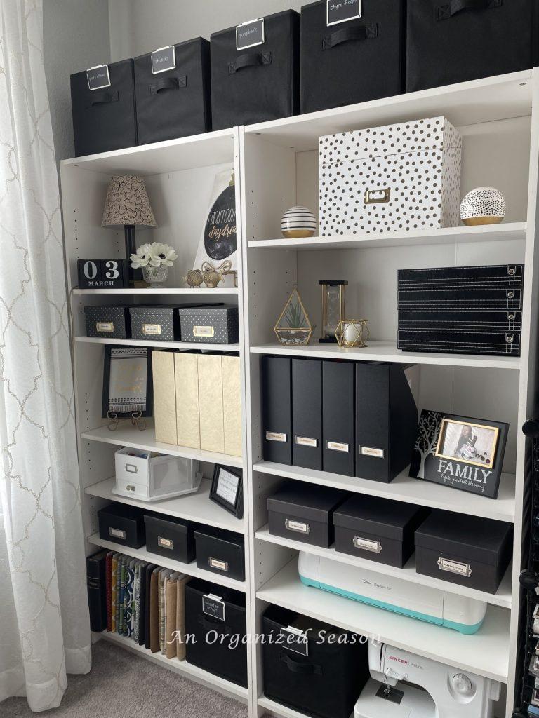 White bookshelves storing office and craft supplies. 