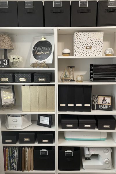 Organized office supplies on white bookshelves.