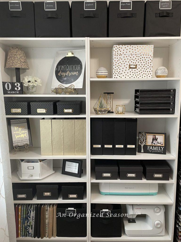White bookshelves storing black, white, and gold organizers.