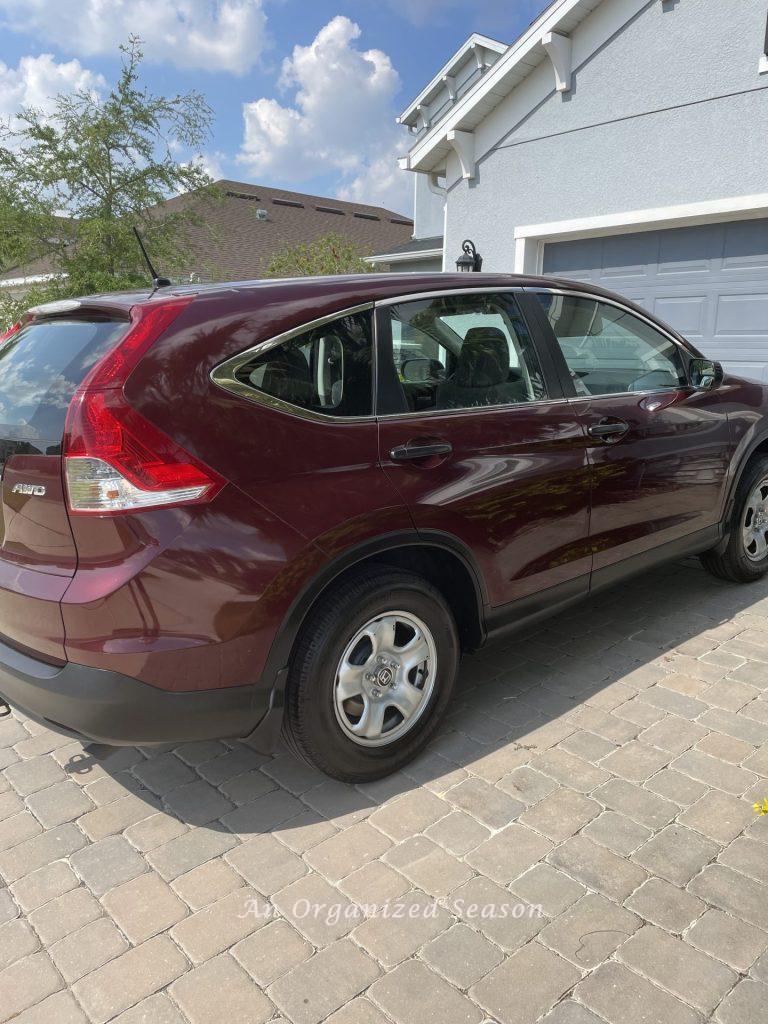 A maroon SUV parked in a driveway. 