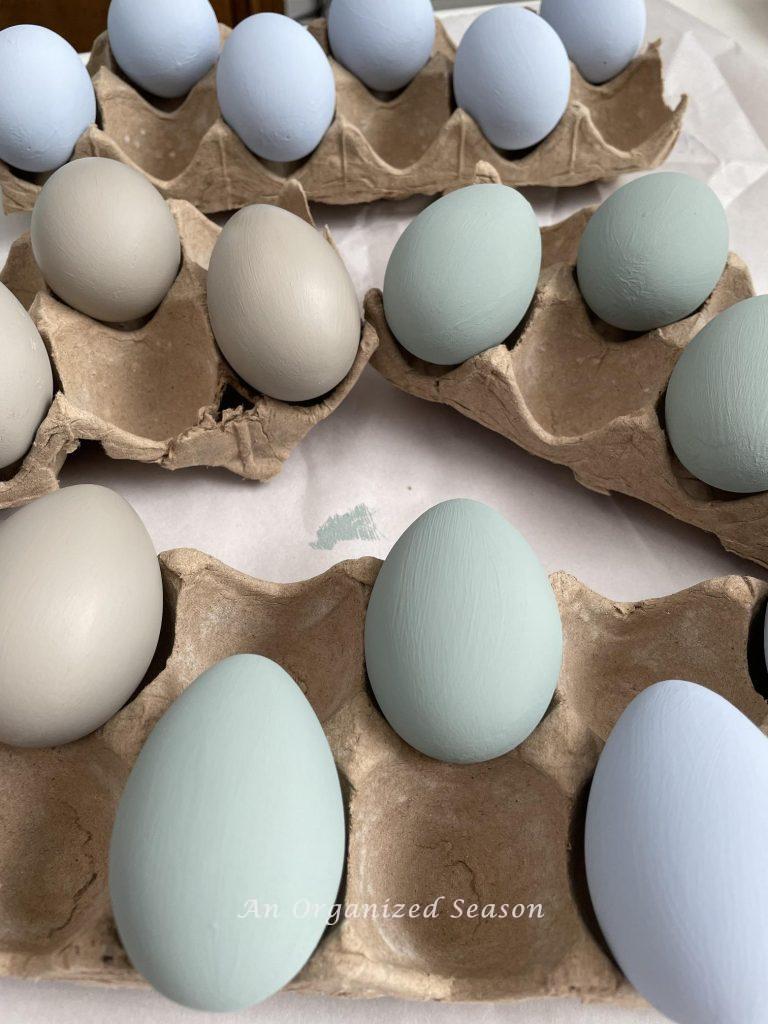 Eggs that have been painted muted shades of tan, green, and blue. 