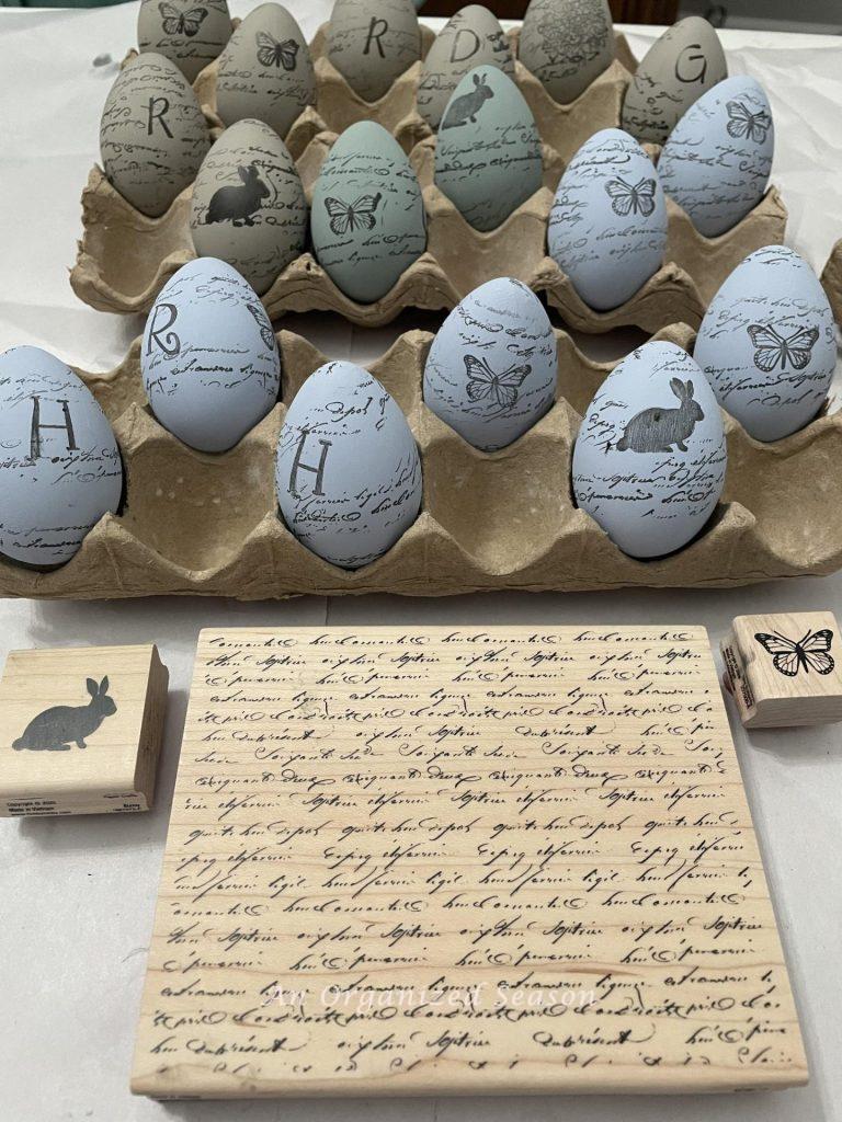 Wood stamps in front of Easter eggs that have been painted and stamped. 