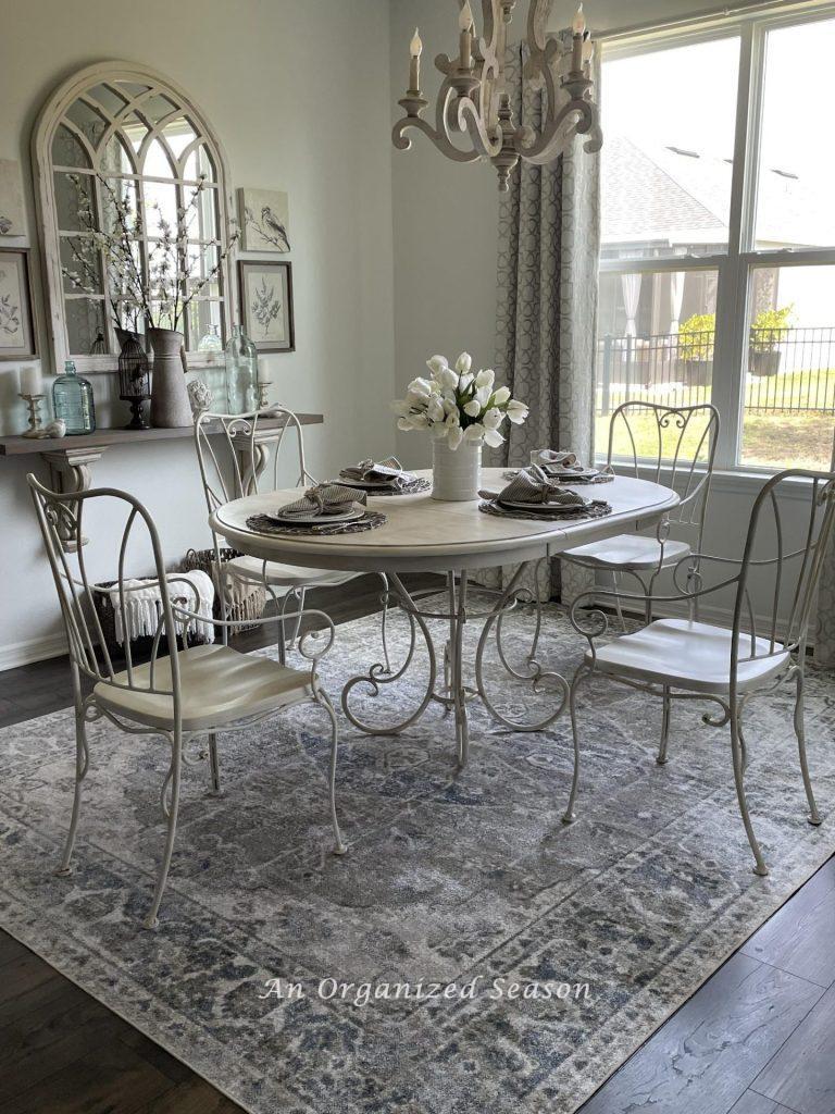 Dining table with chairs pulled out showing how to choose the right size rug for a dining table.