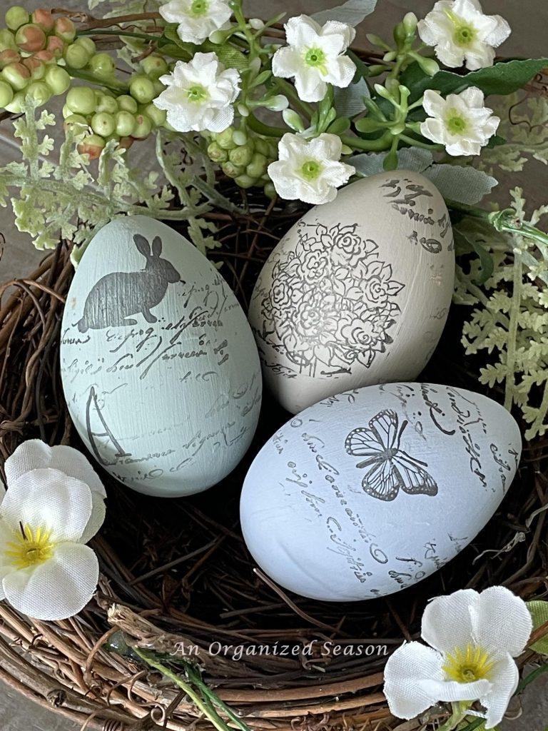 Three painted and stamped Easter eggs in a bird nest. 