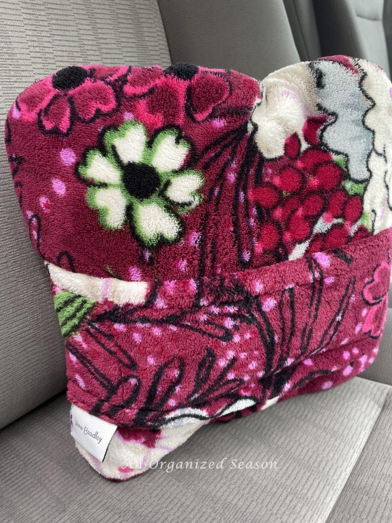 A travel pillow and blanket combo in a car. 