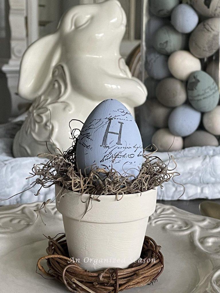 A painted and stamped Easter egg in a small flower pot. 