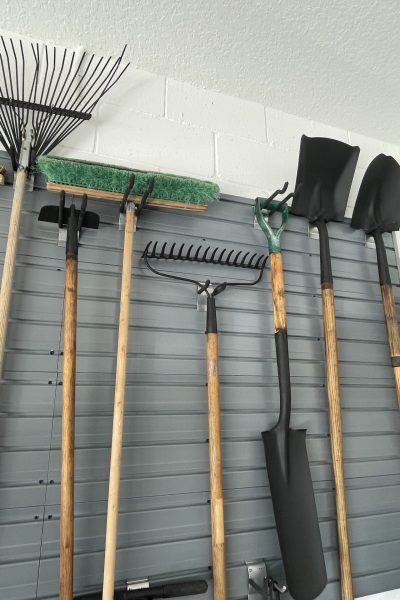 Organized tools hanging on a garage wall.