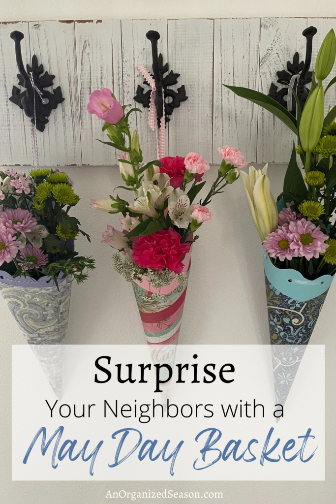 Three flower arrangements hanging in paper cones