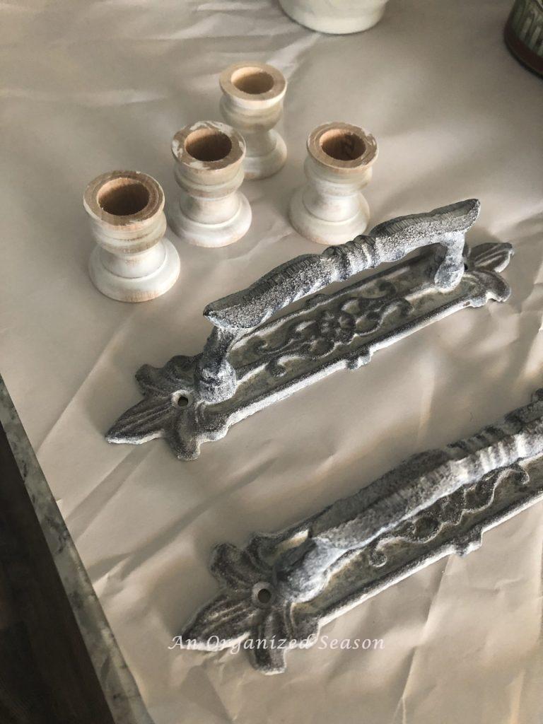 Paint candlestick holders and metal handles white before putting them on the DIY wood board.