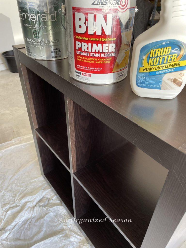 Step one to paint laminate cabinets is to gather supplies like Cleaner, primer, and paint. 