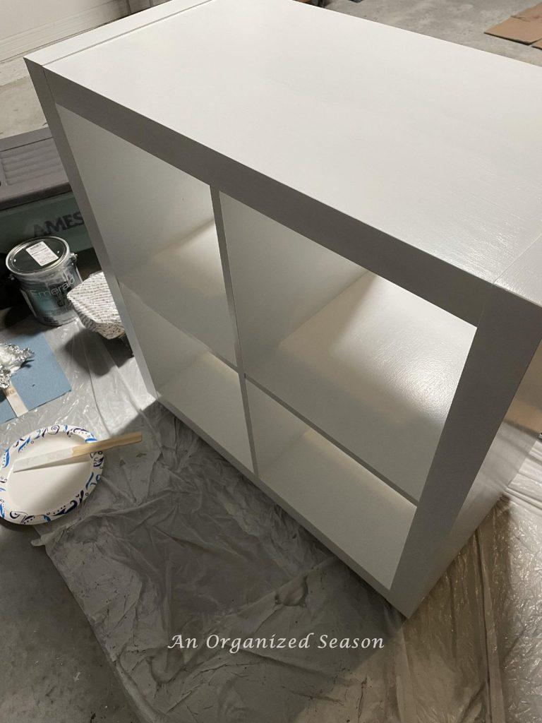 A laminate cabinet with one coat of white paint.