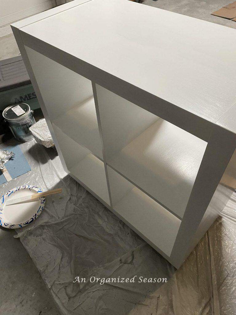 A laminate cabinet with one coat of white paint. 