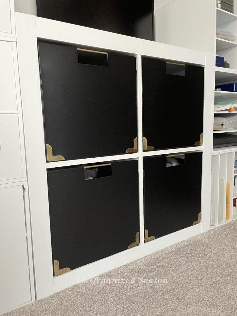 A white storage cabinet with black cubes.