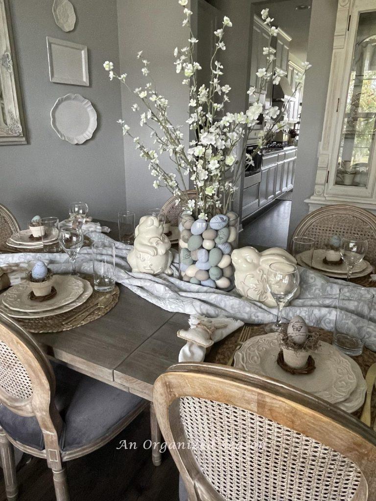 A dining room table decorated and set for Easter dinner.