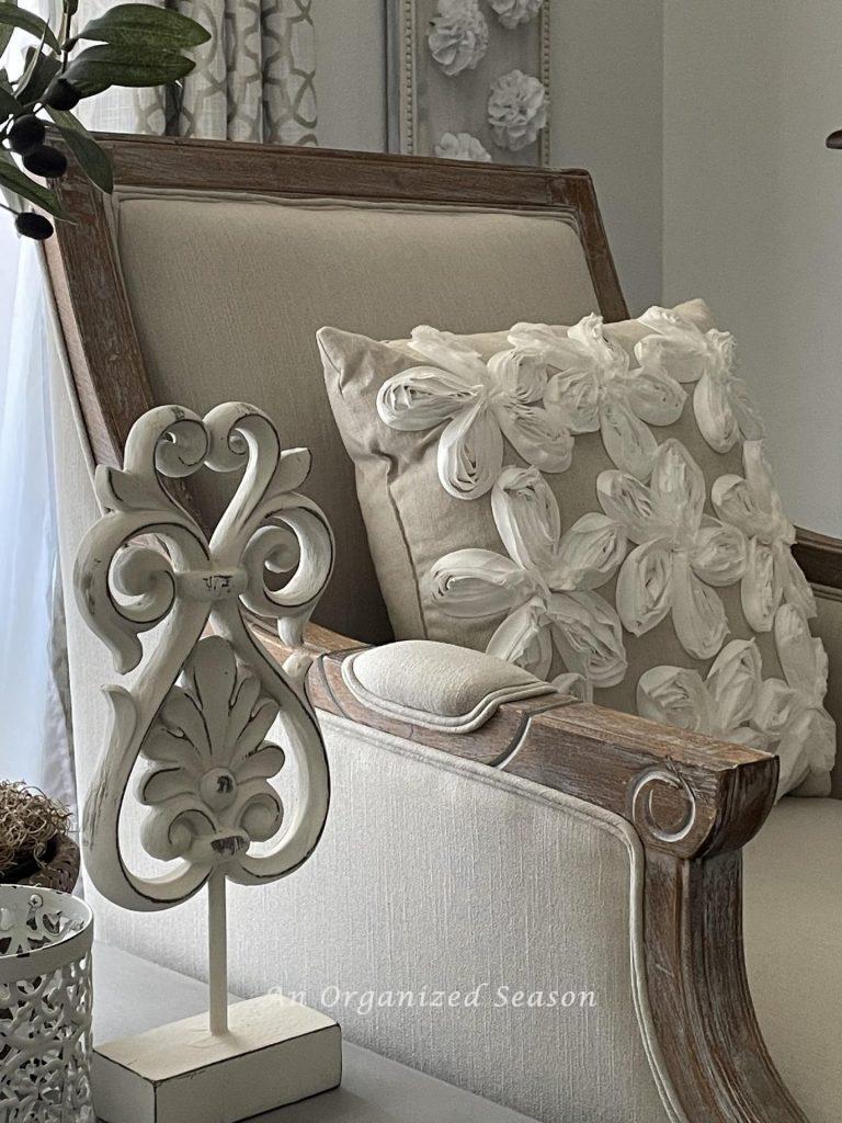 A linen pillow with white flowers on the front.  