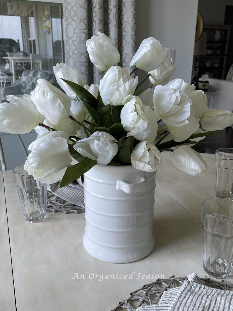 White tulips in a white vase are a perfect decorating idea for a Spring centerpiece.