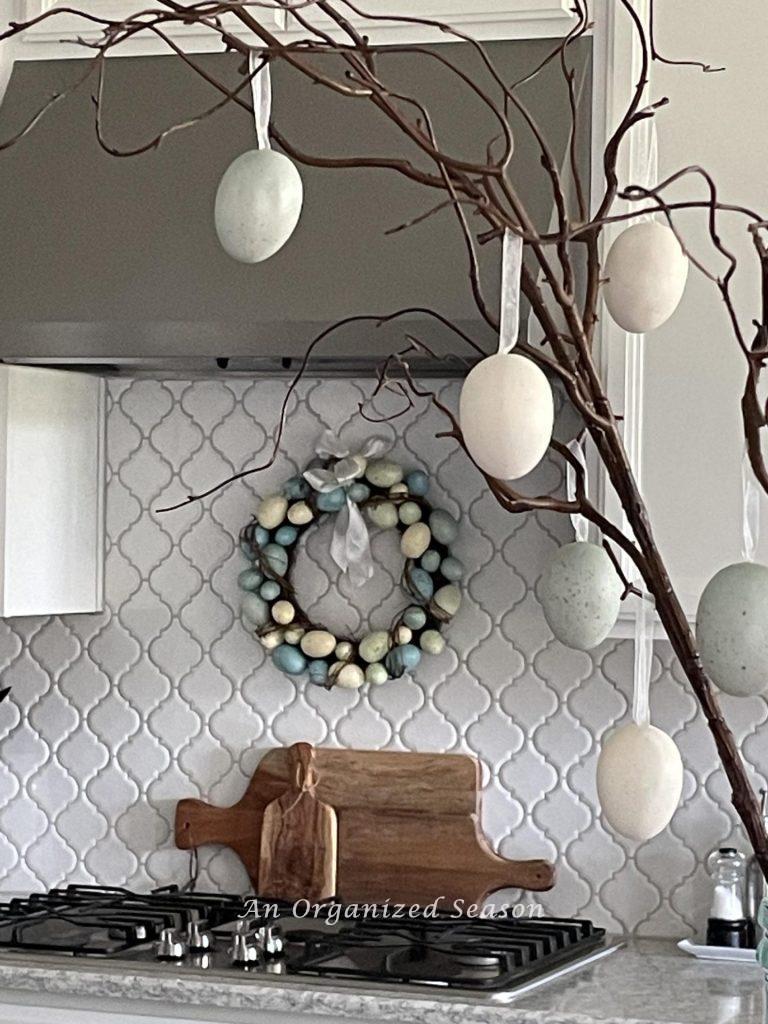 A wreath made of Easter eggs hanging over a stove. 