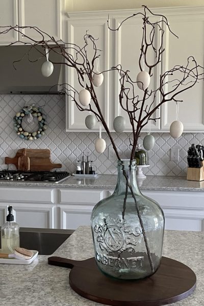 branches in large vase with Easter eggs hanging on them