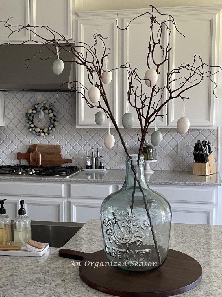 Branches in a big glass vase with Easter eggs hanging on them is a great spring decorating idea.