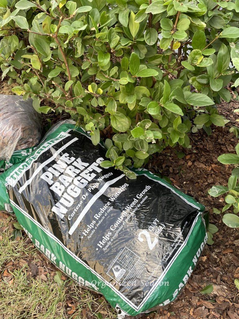 Bags of mulch laying in a plant bed. 