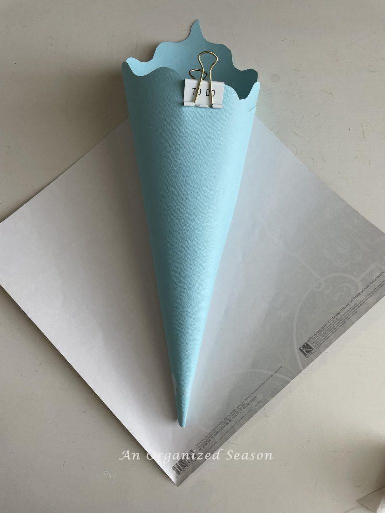 Blue cardstock rolled into a cone and clipped together. 