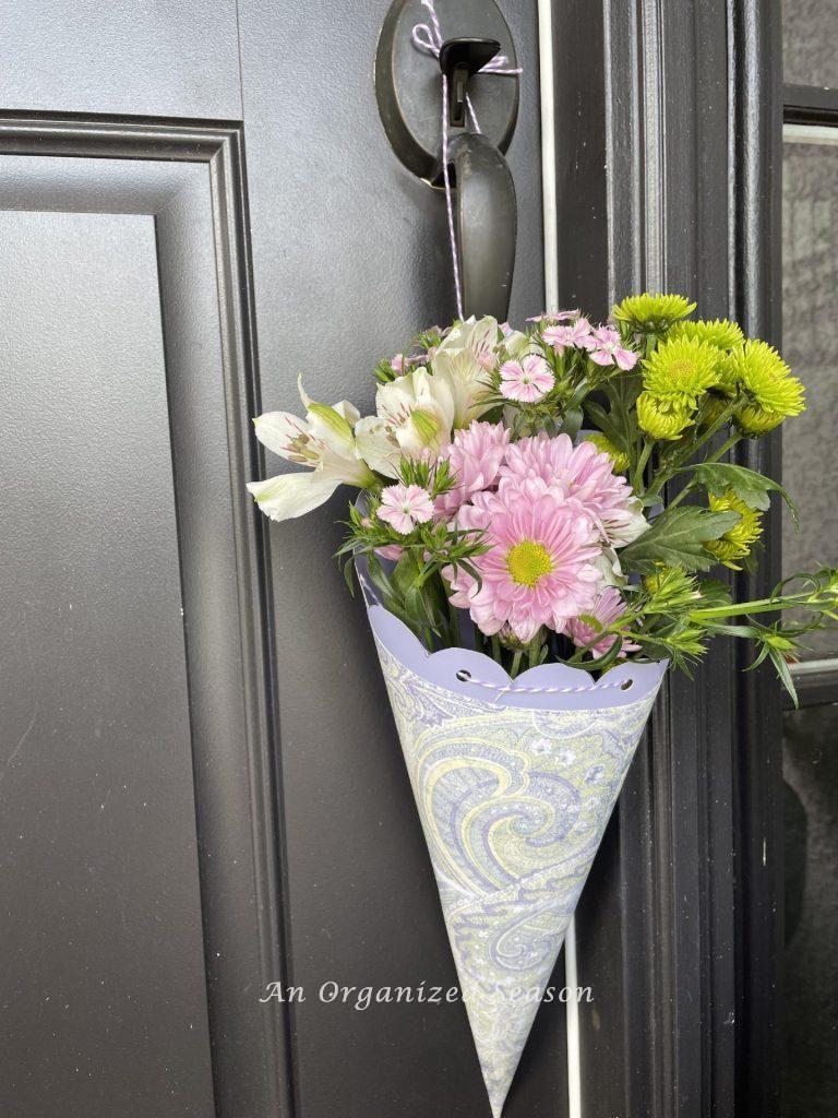 A purple May Day basket hanging on a front door. 