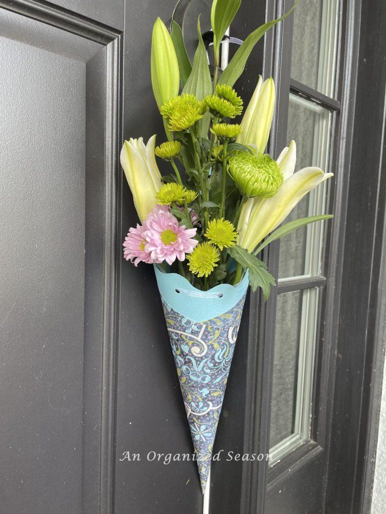 A blue May Day basket hanging on a front door. 