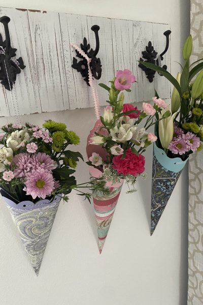 Three paper baskets filled with flowers