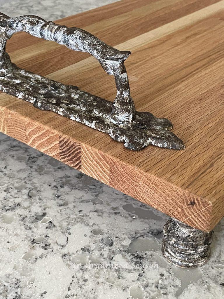 Rustic paint job on the handles and feet of a wood tray.