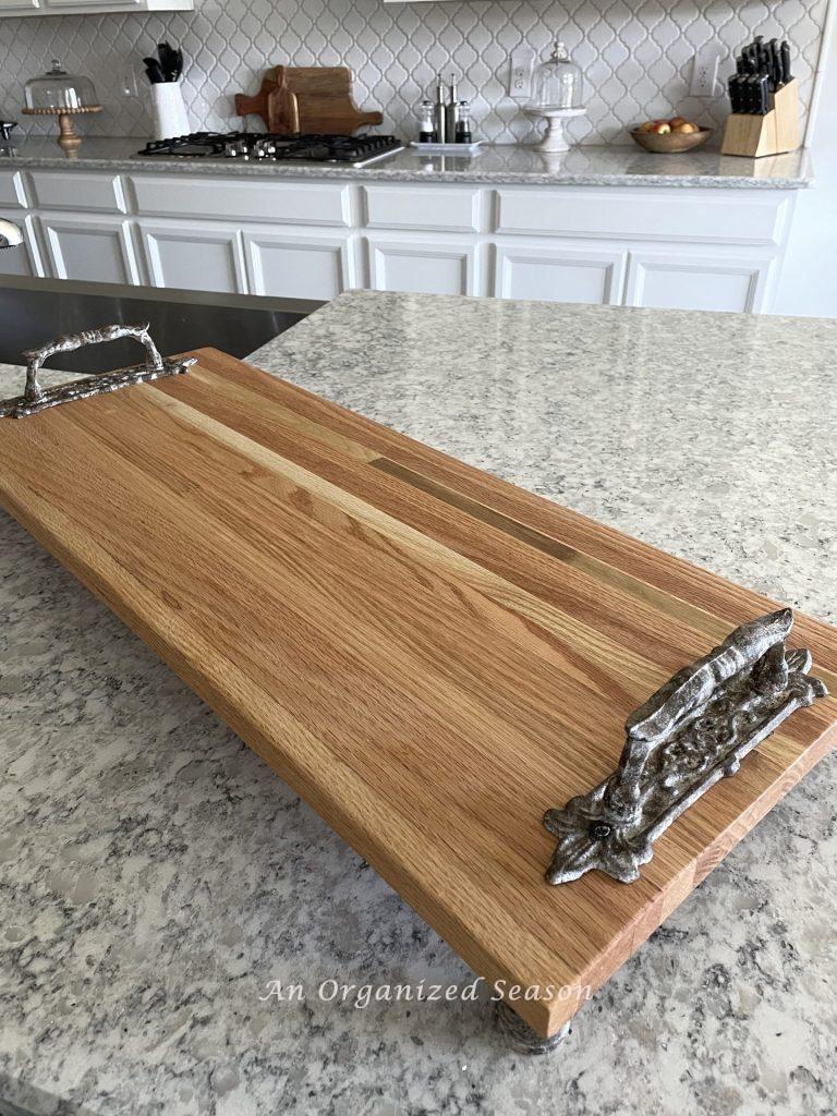 A wood tray with ornate handles. 