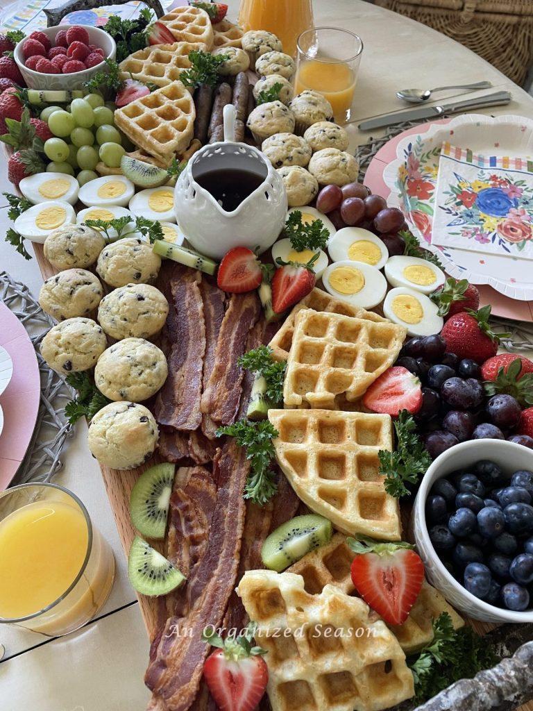 A wood board with a sampling of breakfast foods. 