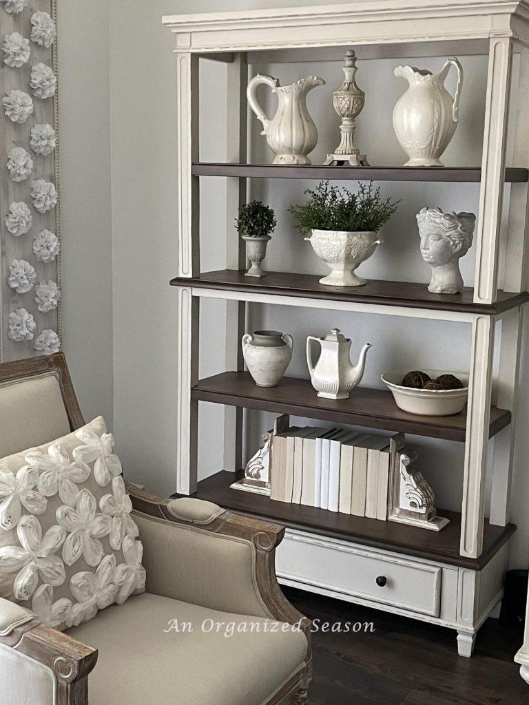 Ironstone thrifted finds displayed on a bookshelf.