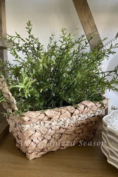 Basket made from packing paper filled with faux plant.