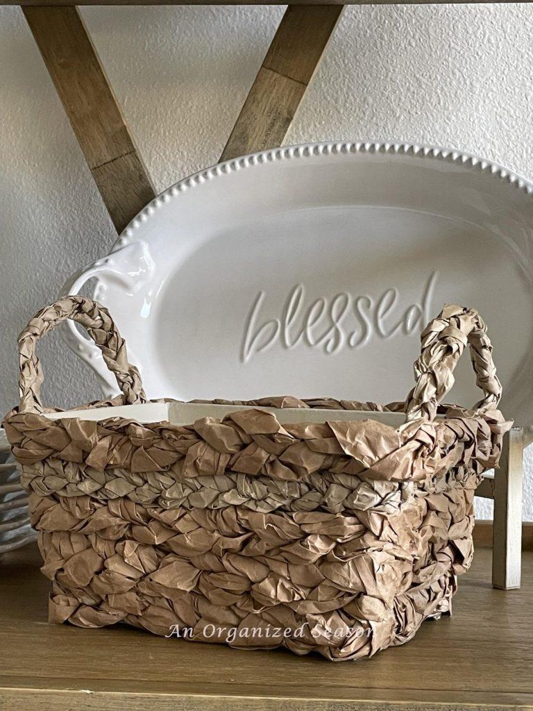 A basket with handles in front of a white platter. 