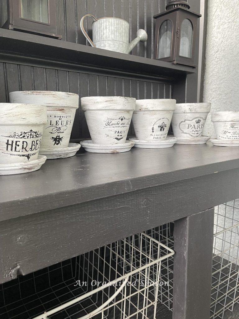 Six French flower pots sitting on a potting bench. 