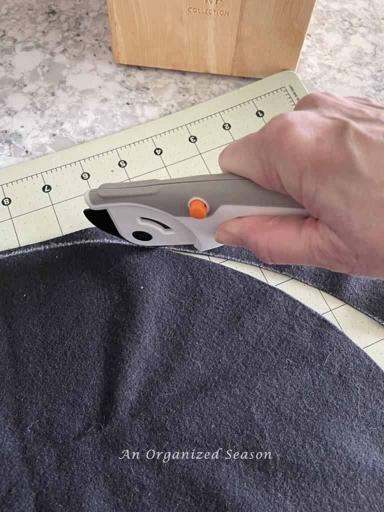 A woman using a cutting blade to cut material. 